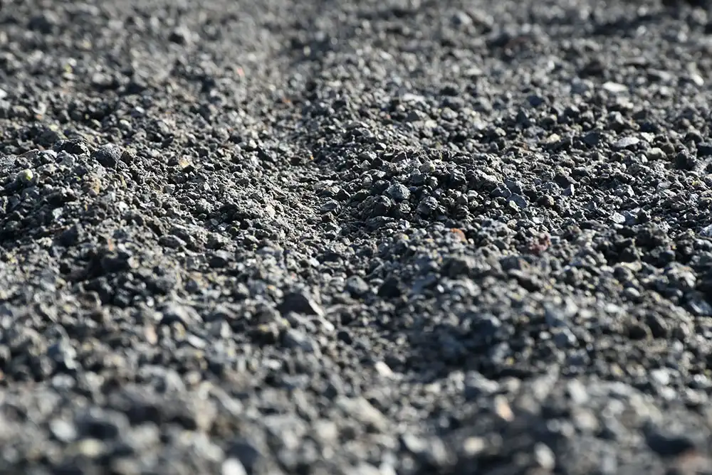 A close-up of crushed asphalt being prepped for a job site.